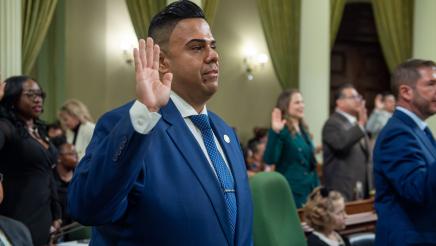 Asm. González holding up one hand