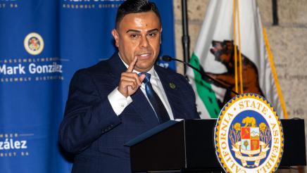 Asm. González at podium, speaking