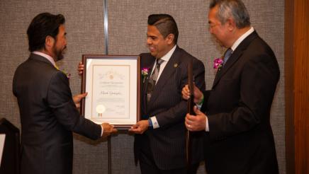 Asm. González being presented with framed award