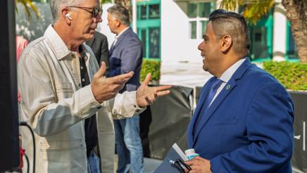 Asm. González speaking with attendee