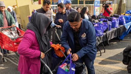 Asm. González loading bag of food for constituent