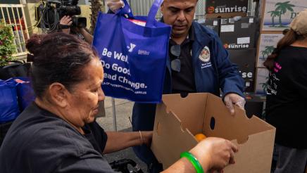 Asm. González loading bag of food for constituent